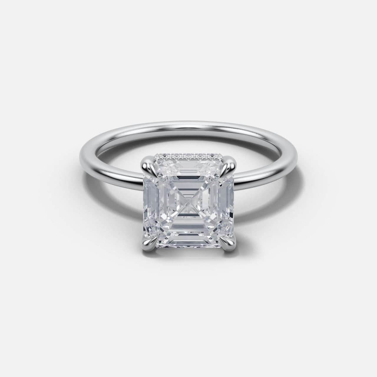 White gold Asscher-cut solitaire tilted to reveal the stone face, hidden halo row and the slim band behind it