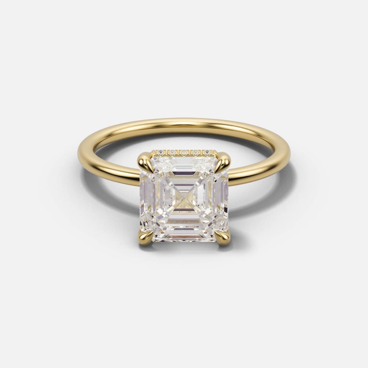 Yellow gold Asscher-cut solitaire tilted back, showing the step-cut table, the fine hidden halo row and the thin band
