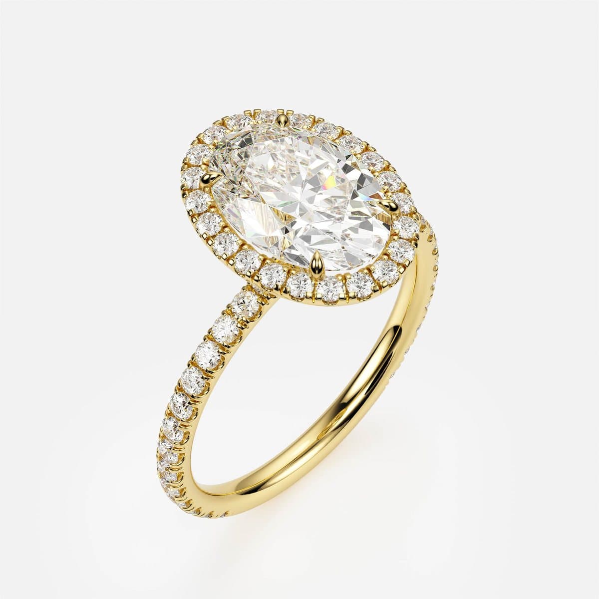 Photorealistic 3D render of nanea's Luminous Halo engagement ring in yellow gold — an oval centre stone in a pavé halo on a slender pavé band, produced by 4rend Studio