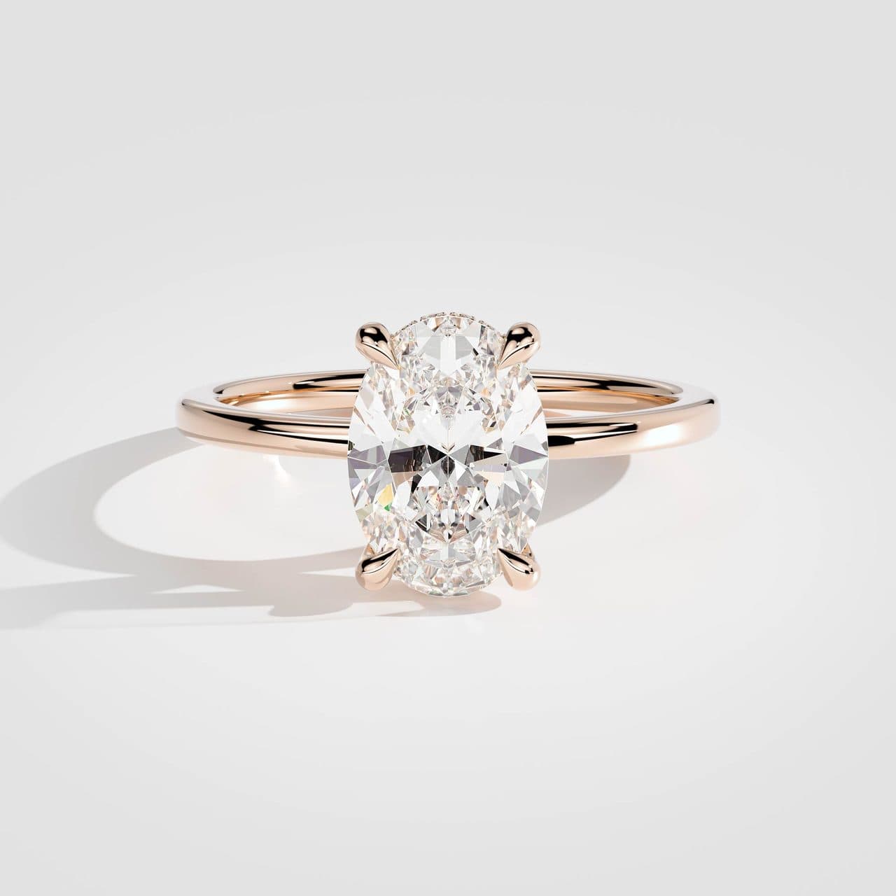 Rose gold oval diamond solitaire from above under the same neutral studio light as the white gold version