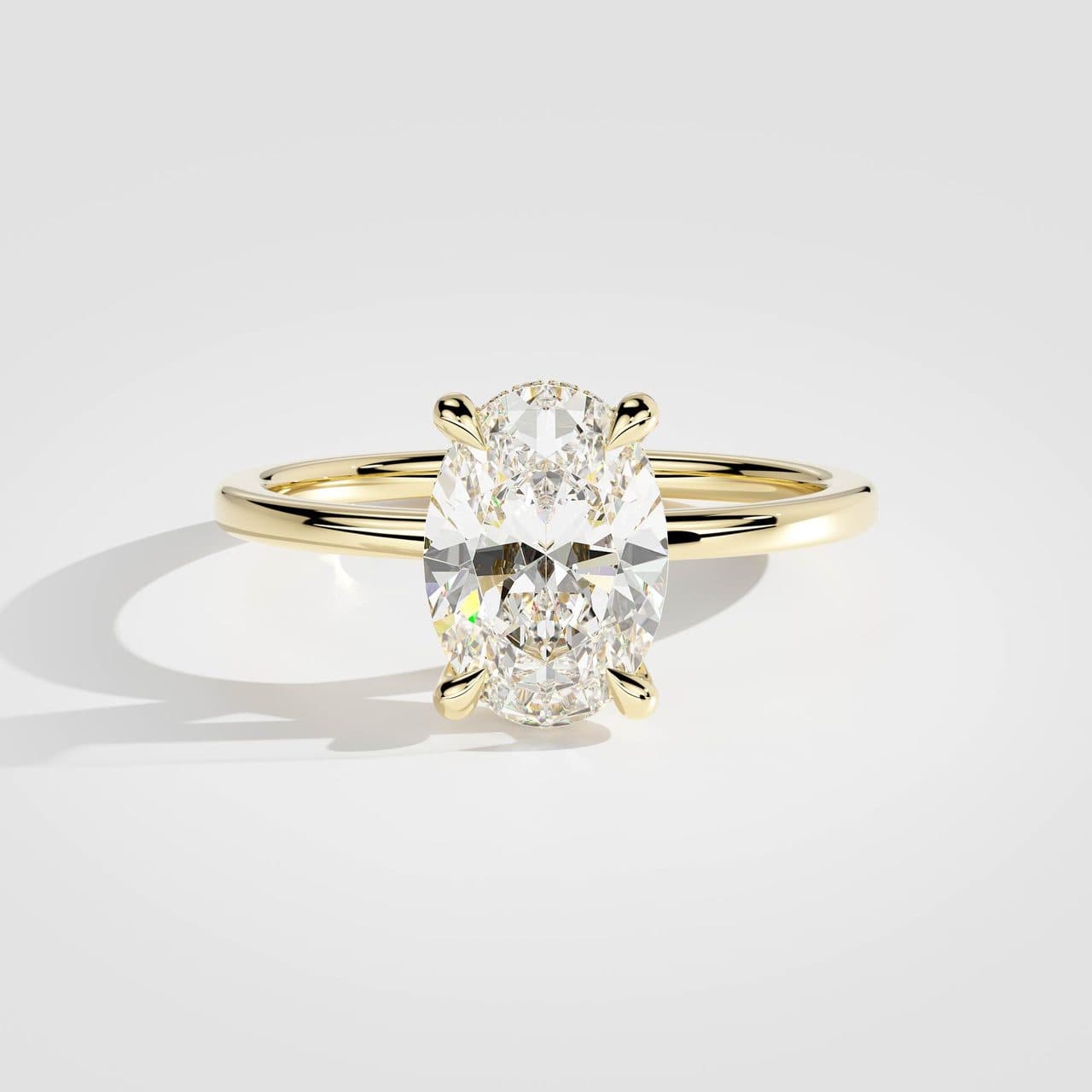 Yellow gold oval diamond solitaire from above under the same neutral studio light as the white and rose gold versions